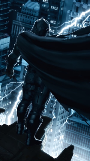 Batman on a rooftop during a lightning storm