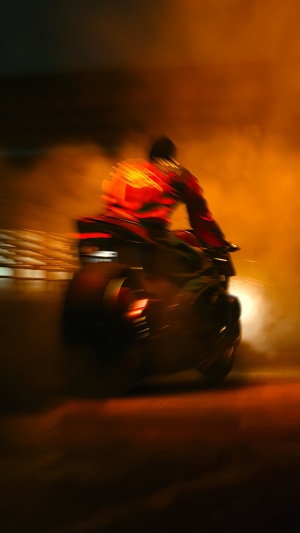 Biker in red suit on motorcycle with smoke