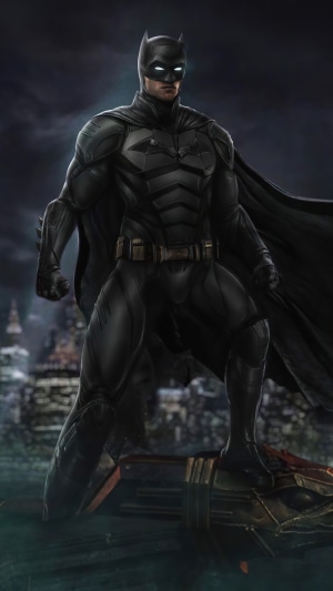 Batman standing on a structure in a city at night