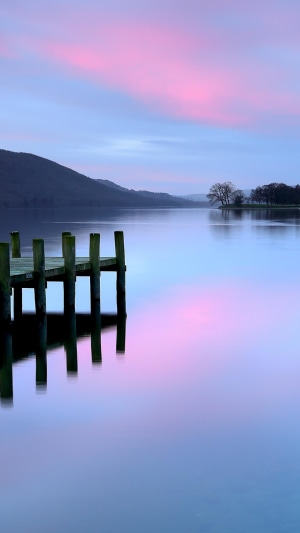 Pier on a lake at dusk with pink clouds