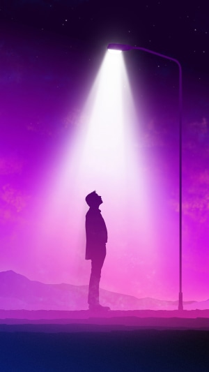 Man standing under a street lamp at night