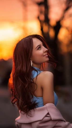 Model in blue top and pink coat at sunset