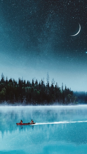Canoe on a lake under a starry night sky