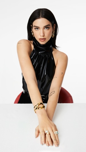 Dua Lipa wearing a black halter top and jewelry