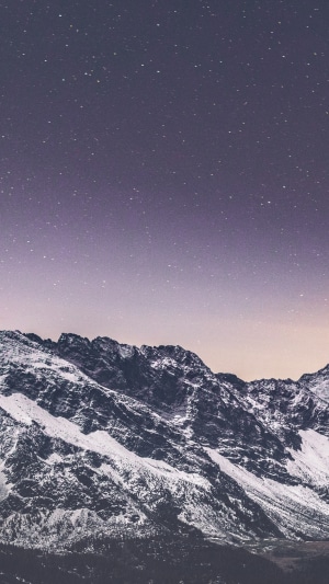 Snowy mountains under a starry night sky 4K