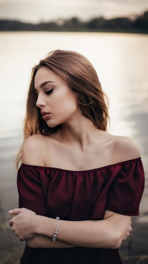 Young woman with off-the-shoulder top by a lake