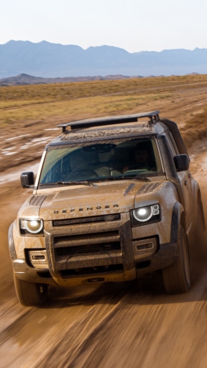 Land Rover Defender driving on a dirt road