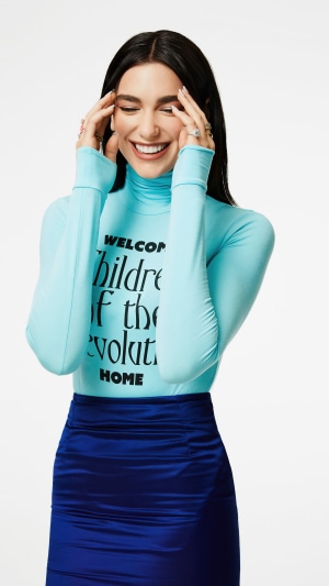 Dua Lipa wearing a blue turtleneck and skirt