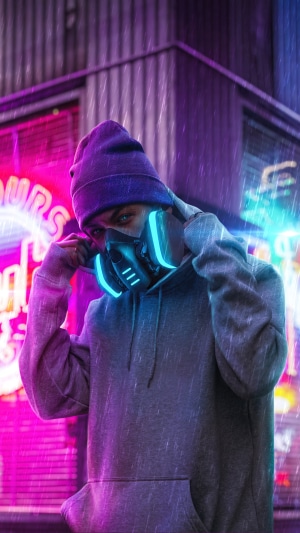 Person in hoodie and gas mask in neon city