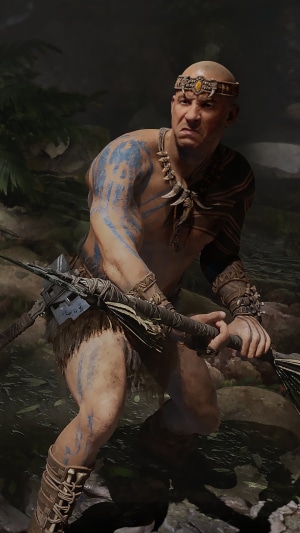 Man with blue body paint and tribal attire holding a spear