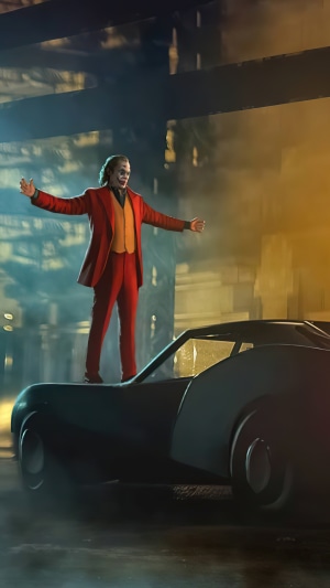 Joker standing on a car