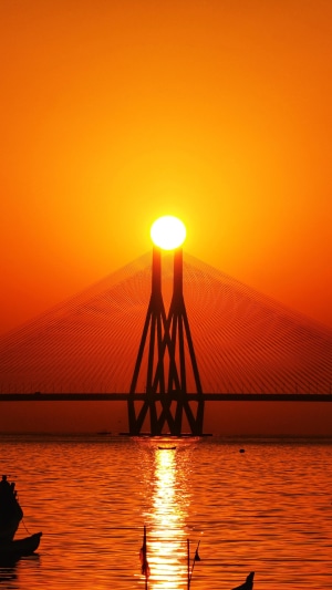 Sunset over a bridge with boats on the water