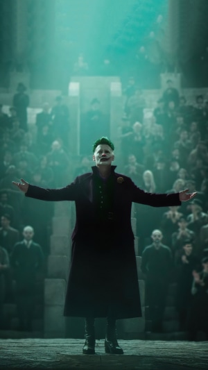 Joker with green hair and makeup in a dark coat