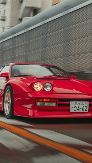 Red Ferrari Testarossa driving on road