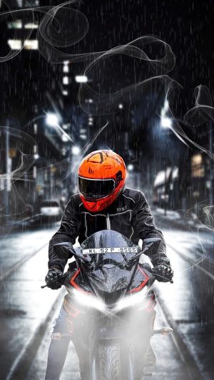 Motorcycle rider in orange helmet on Yamaha motorcycle in rain