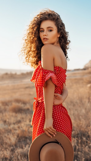 Girl in red polka dot dress in a field