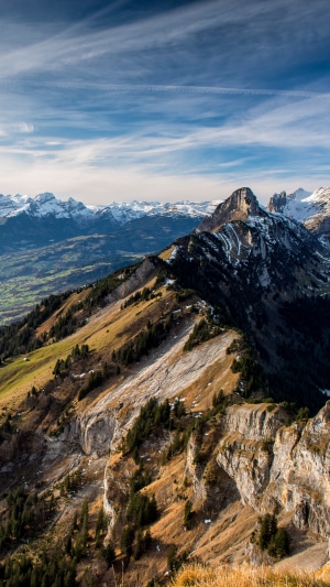 Mountain range with snow-capped peaks and forested slopes