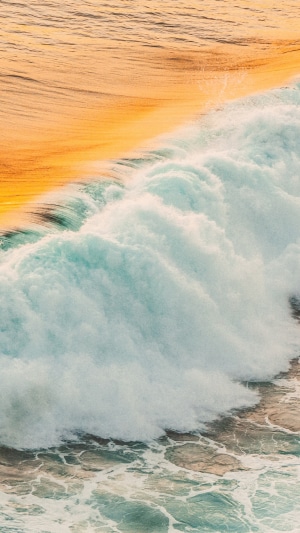 Ocean waves crashing with golden light