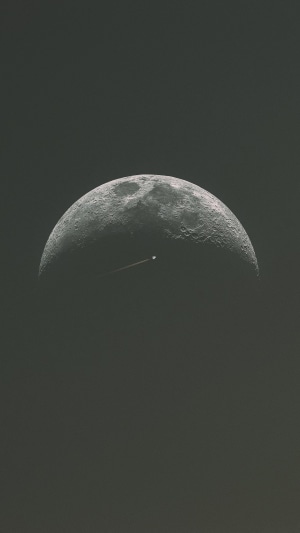 Airplane flying past the moon