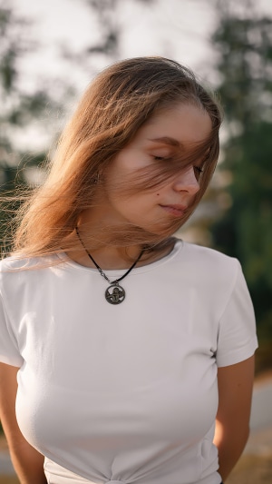Girl with windblown hair and necklace