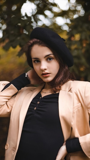 Young woman wearing a black beret and beige blazer