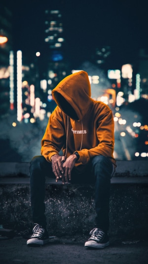 Person in hoodie sitting at night