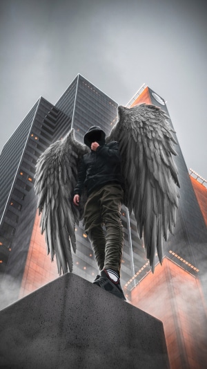 Man with angel wings in front of skyscrapers