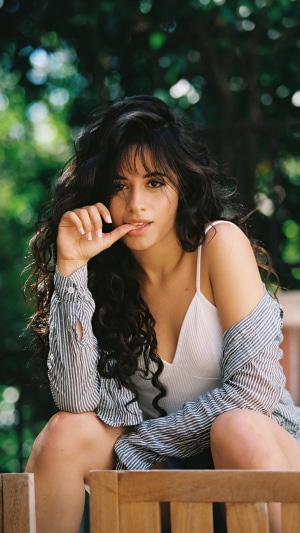 Camila Cabello sitting outdoors