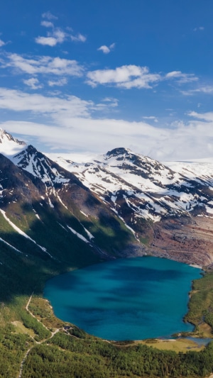 Turquoise lake surrounded by snowy mountains in Norway