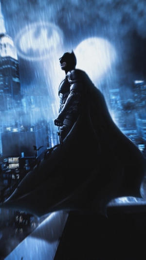 Batman in the rain with the Bat-Signal