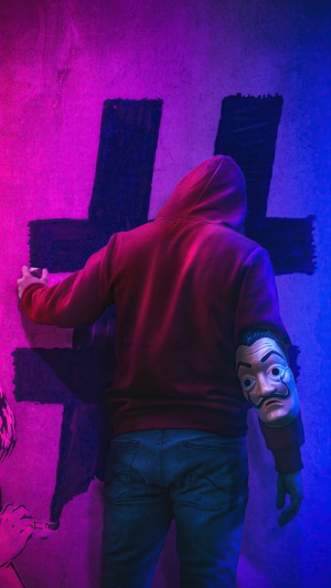 Person in hoodie spray painting a hashtag symbol