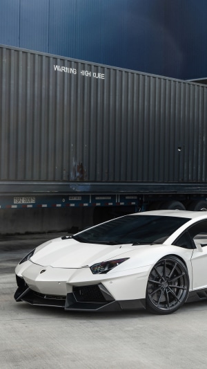 White Lamborghini Aventador parked near a shipping container
