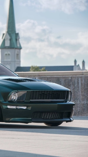 Dark green Ford Mustang with racing stripes