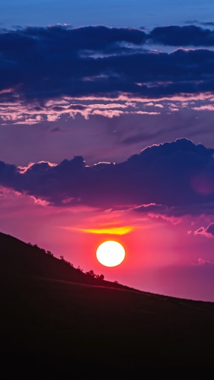 Sunset over a silhouetted hill