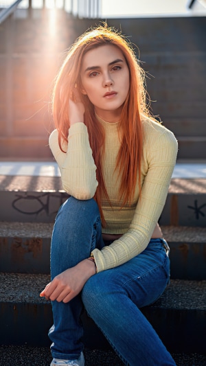 Model with red hair sitting on stairs