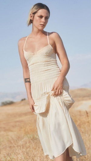 Kristen Stewart in a cream dress in a field