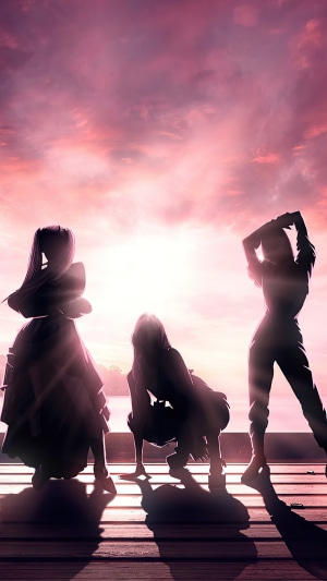 Blackpink members posing against a sunset sky