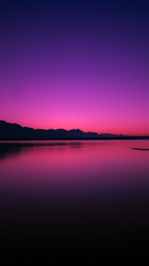 Purple sunset over a lake and mountains