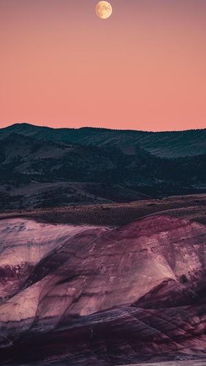 Full moon over painted hills at sunset