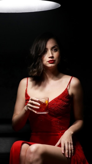 Ana de Armas in a red dress holding a drink