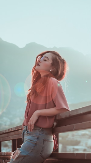 Woman wearing sunglasses and ripped jeans