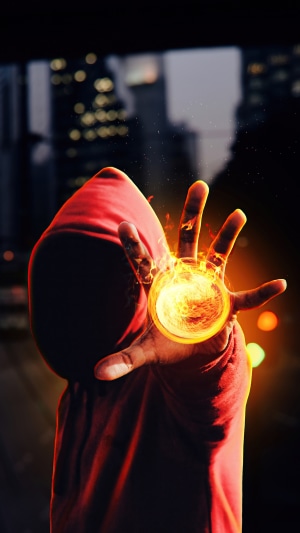 Person in red hoodie holding a ball of fire