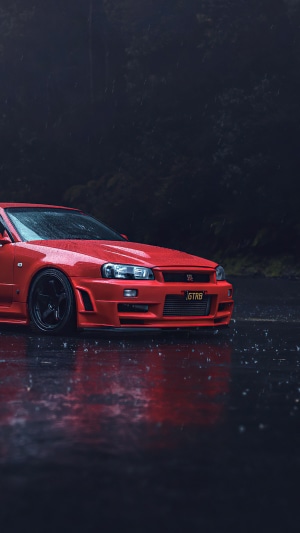 Red Nissan GT-R R34 in the rain