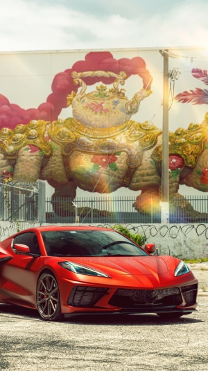 Red Chevrolet Corvette Stingray C8 in front of mural