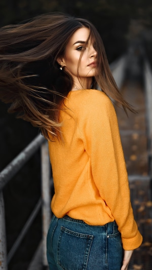 Model wearing orange sweater and jeans