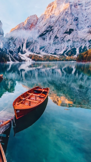 Wooden boat on a clear lake with mountains