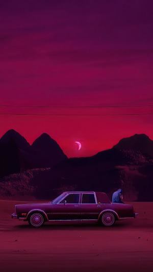 Person sitting on a car at sunset