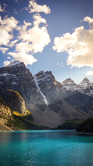 Turquoise lake with snow-capped mountains and clouds
