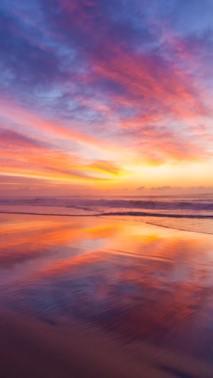 Beach with colorful sunrise and reflection