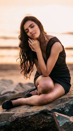 Model in black dress on beach rocks 4K
